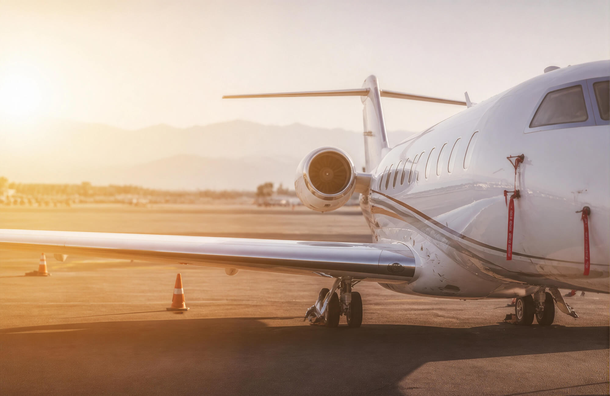 Business jet on the apron at sunset, seen from behind the wing
